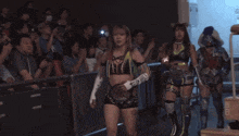 a woman wearing boxing gloves with chinese writing on them stands next to another woman