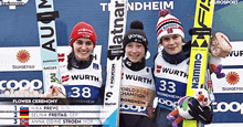 three skiers are posing for a picture and one of them has the number 33 on her skis