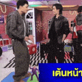 two men are standing next to each other in a room with a sign that says live house on it