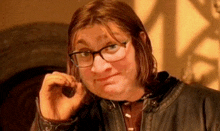 a man wearing glasses and a leather jacket is making a funny face