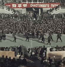 a crowd of people are gathered in front of a sign that says " счастливого путь "