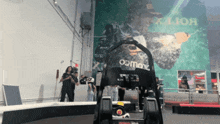 a go kart is in front of a rolex mural