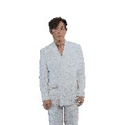 a man in a white suit is covering his ears