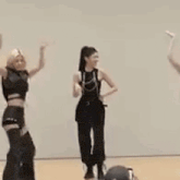 a group of women are dancing in a room while a man watches .