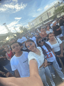 a group of people posing for a picture with one wearing a shirt that says ll 23