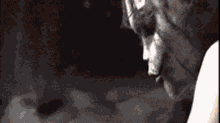 a black and white photo of a person 's face in a dark room