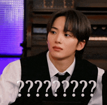 a man wearing a vest and tie has a question mark on his chest