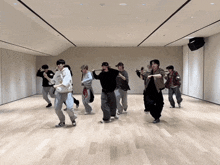 a group of young men are dancing in a room with a large mirror