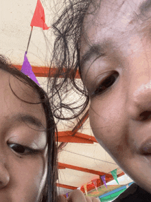 a close up of a person 's face with a purple flag in the background