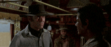 a man in a hat is talking to another man