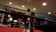 a man with a tattoo on his back is standing in a ring