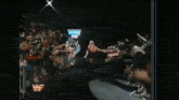 a wrestler is walking through a crowd of people with a sign above his head that says wrestlemania