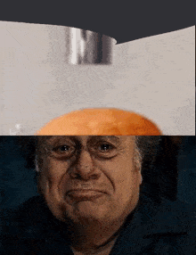 a close up of a man 's face with a hamburger on top of him
