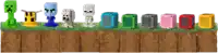 a row of minecraft toys are lined up on a grassy hill