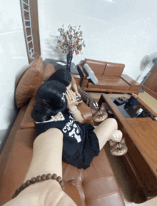 a woman sitting on a couch wearing a shirt that says cwcl on it