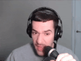 a man wearing headphones is holding a microphone in his hand