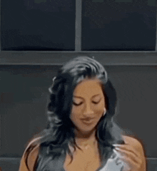 a woman with long black hair is holding a telephone in her hand .