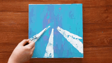 a person is painting a blue and white picture