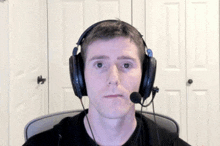 a man wearing headphones and a microphone making a face