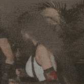a woman in a white tank top has a black belt around her waist and a black glove