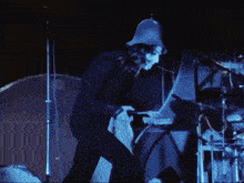 a man wearing a knight 's helmet is playing a drum set