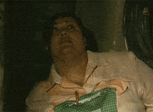 a woman wearing a pink shirt and a green apron is making a funny face
