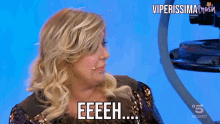 a woman with blonde hair says eeeeh on a blue background