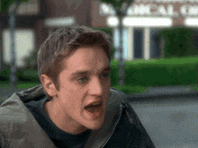 a man is making a funny face in front of a building that says mccall