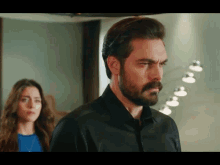 a man with a beard and mustache is standing next to a woman