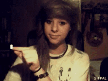 a girl in a white shirt is holding something in her hand and the gifpal logo is visible