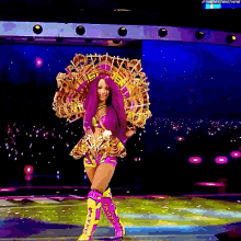 a woman with purple hair is standing on a stage wearing a costume .