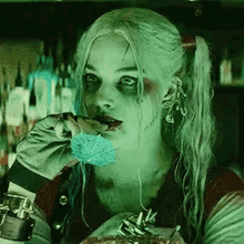 harley quinn from the movie suicide squad is eating a piece of cake with a spoon .