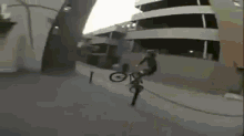 a person is doing a trick on a bike in front of a building