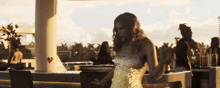 a woman in a gold dress dancing in a bar