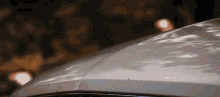 a close up of the hood of a silver car