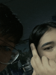a man and a woman are posing for a picture and the woman is covering her mouth with her hand