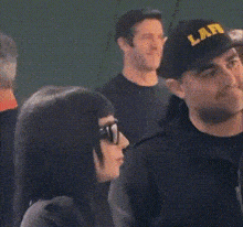 a man and a woman are sitting in a crowd of people .