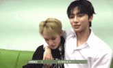 two young men sitting next to each other with chenle written on the bottom of the screen