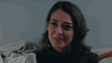 a woman is smiling and holding a blanket in her lap