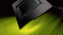 a computer monitor is sitting on a table with a yellow light coming out of it