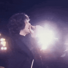 a man is singing into a microphone in a dark room .