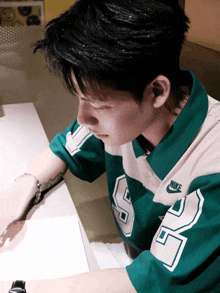 a man wearing a green and white nike shirt