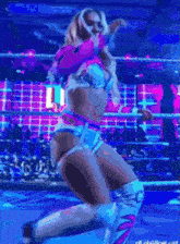 a woman in a wrestling ring with the letter l on the screen