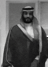 a black and white photo of a man in a traditional arabic outfit
