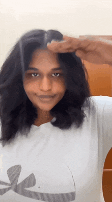 a woman wearing a white t-shirt with a palm tree on it
