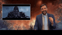 a man in a suit and tie is laughing in front of a video of a castle