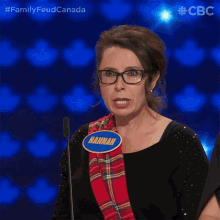 a woman wearing glasses and a name tag that says hannah stands in front of a microphone