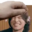 a close up of a person 's face with a hand holding it over it .