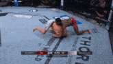 two men are wrestling in a ufc ring with a jurassic world logo behind them