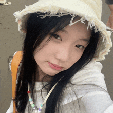 a young girl wearing a white hat and a necklace